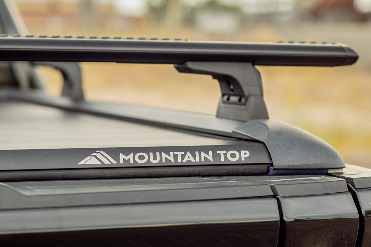 close up of a mountain top tonneau cover on a black pick up truck